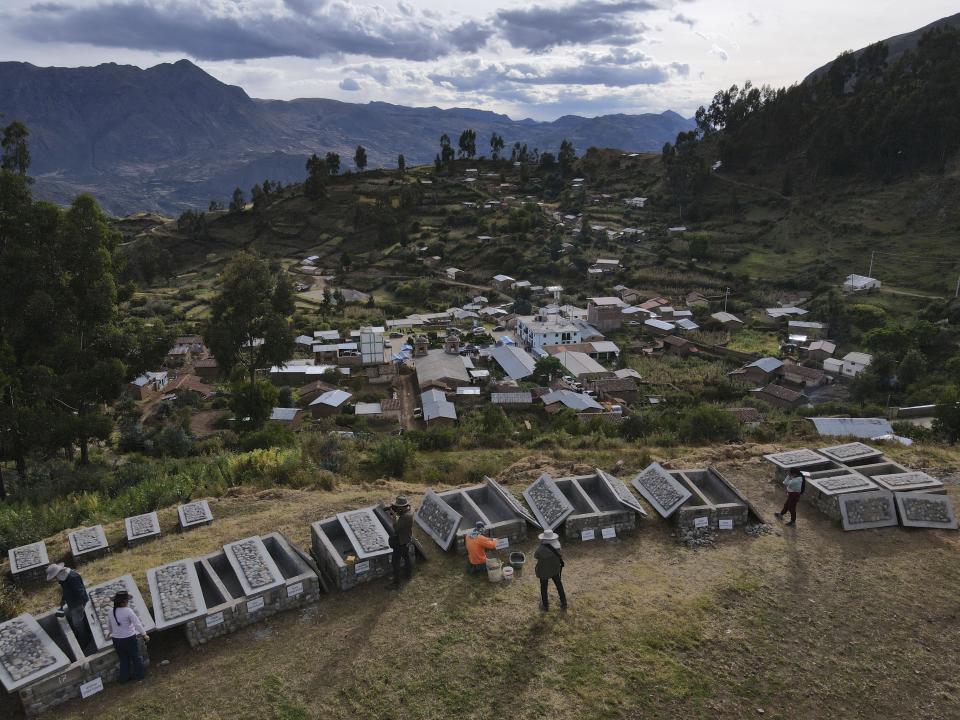 A worker puts the names on empty tombs at a cemetery on what used to be an army base, where the remains of victims killed during the Maoist-inspired insurgency will be buried days after they were turned over to families in Accomarca, Peru, Thursday, May 19, 2022. Peruvian authorities identified the remains of 80 people found in this community as men, women and children who were killed between 1980 and 2000 by both members of the Shining Path militant group and army soldiers. (AP Photo/Martin Mejia)