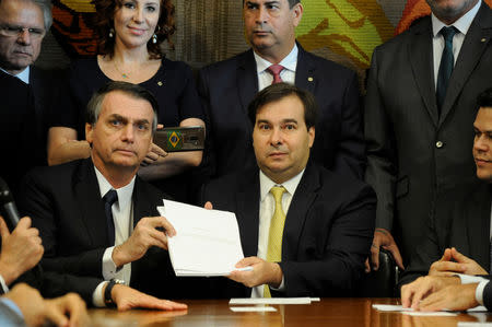 Brazil's President Jair Bolsonaro and Lower House President, Rodrigo Maia pose with the proposal of the pension system reform bill at the National Congress in Brasilia, Brazil February 20, 2019. Luis Macedo/Lower House of Congress/Handout via REUTERS
