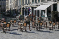 En dueño de un café mide la distancia entre las meses para respetar las normas de distanciamiento social en Lille, en el norte de Francia, el martes 2 de junio de 2020. (AP Foto/Michel Spingler)