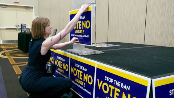 PHOTO: Field organizer Jae Grey places signs on the podium before the abortion rights advocate Kansas for Constitutional Freedom primary election watch party in Overland Park, Kansas, Aug. 2, 2022.  (Dave Kaup/AFP via Getty Images)