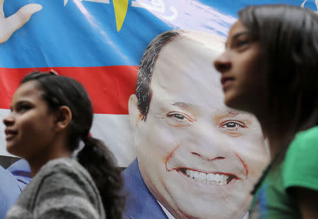 Girls walk by a poster of Egyptian President Abdel Fattah al-Sisi for the upcoming presidential election, in Cairo, Egypt March 19, 2018. REUTERS/Mohamed Abd El Ghany