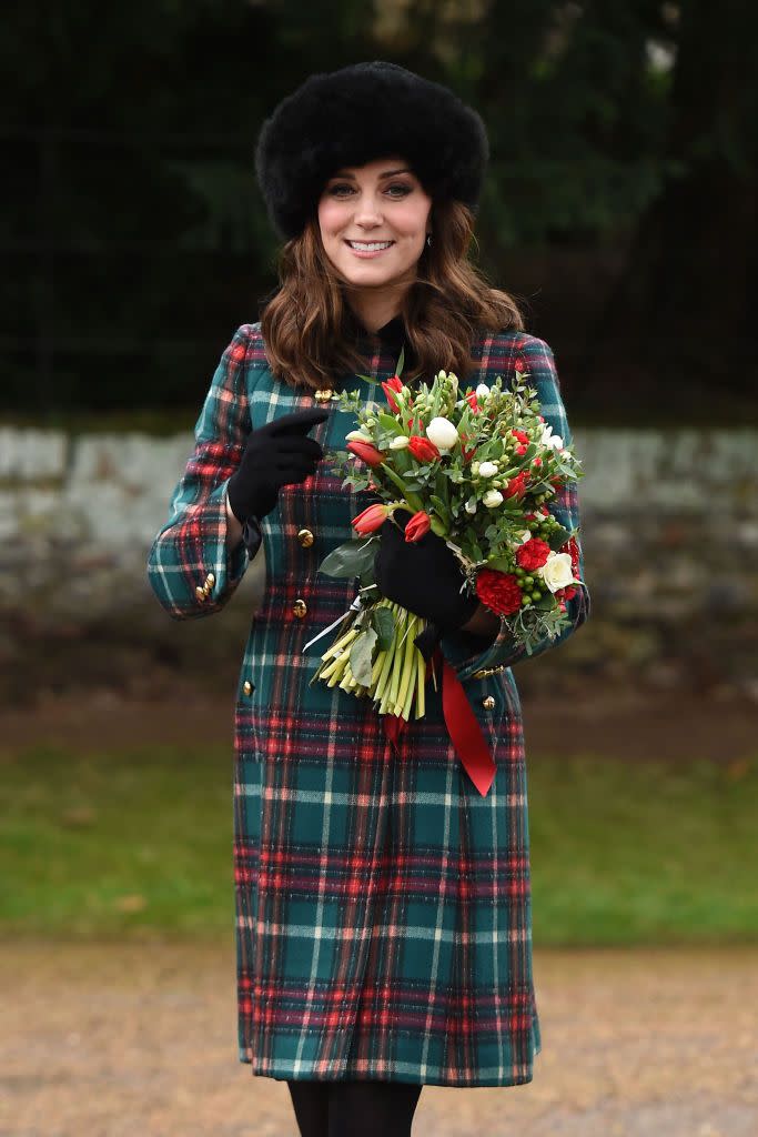 <p>Kate looked festive on Christmas Day in a red and green plaid coat paired with black gloves and a fur hat. </p>