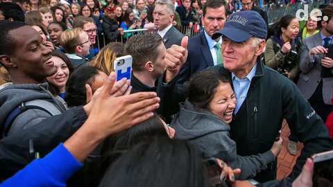 A student hugs UD alumnus and former Vice President Joe Biden who gives a thumbs up to students as he rolls through the crowd in his public return to campus in April 2017.