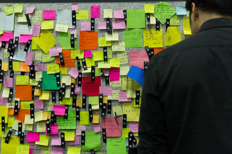 A man reads notes left for the victims of the sunken South Korean ferry "Sewol" at a newly opened memorial altar in Ansan on April 23, 2014