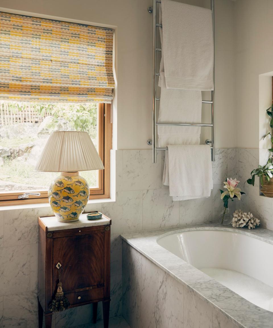 White bath towels hanging from a heater above a bath