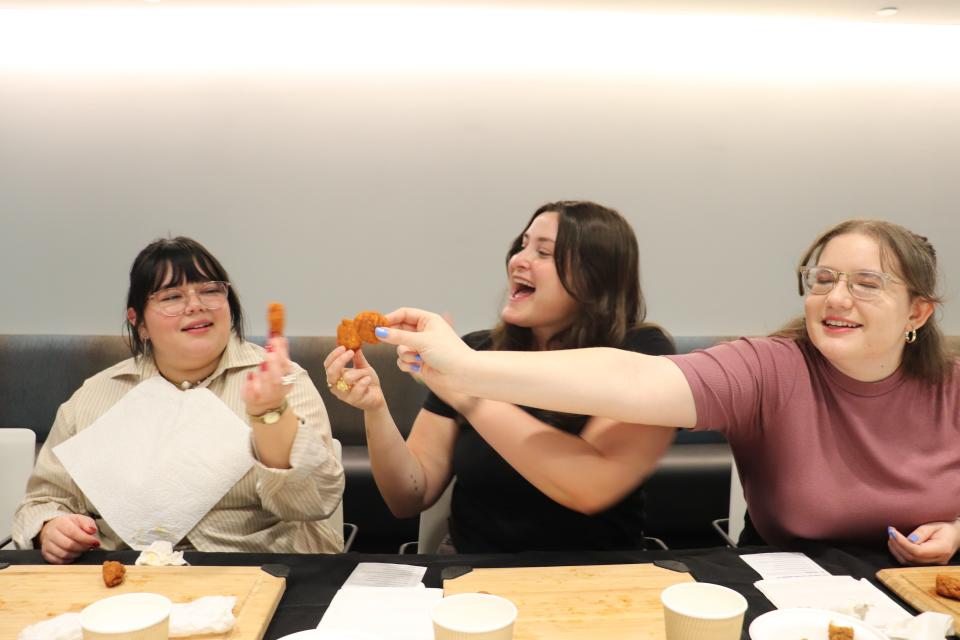 Three of Insider's reporters preparing to eat chicken wings.