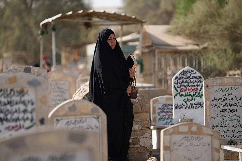 An Iraqi woman visits a relative's grave during the first day of the Muslim feast of Eid al-Adha in Baghdad, Iraq, Saturday, July 9, 2022. Eid al-Adha marks the willingness of the Prophet Ibrahim (Abraham to Christians and Jews) to sacrifice his son. During the holiday, which in most places lasts four days, Muslims slaughter sheep or cattle, distribute part of the meat to the poor and eat the rest. (AP Photo/Hadi Mizban)