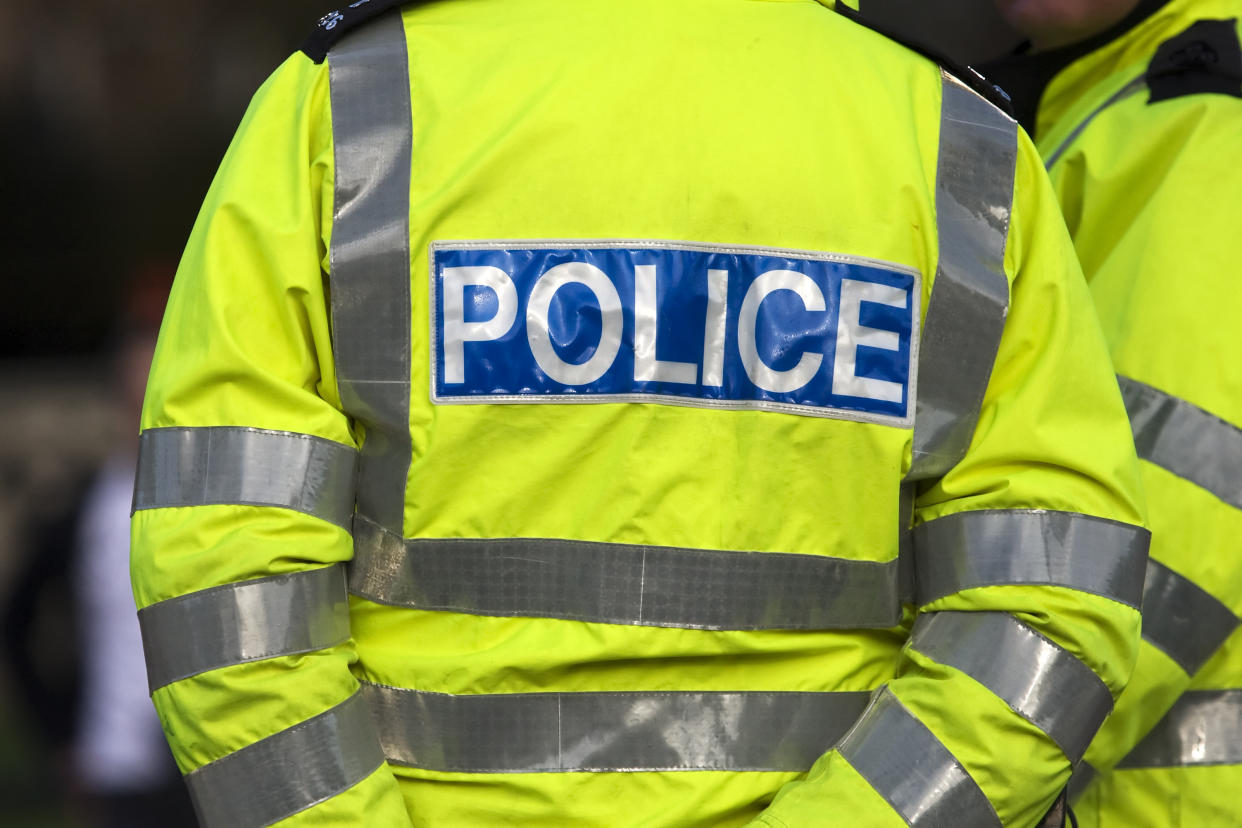 Shot of the back of a police officer's jacket with the word police written across the back