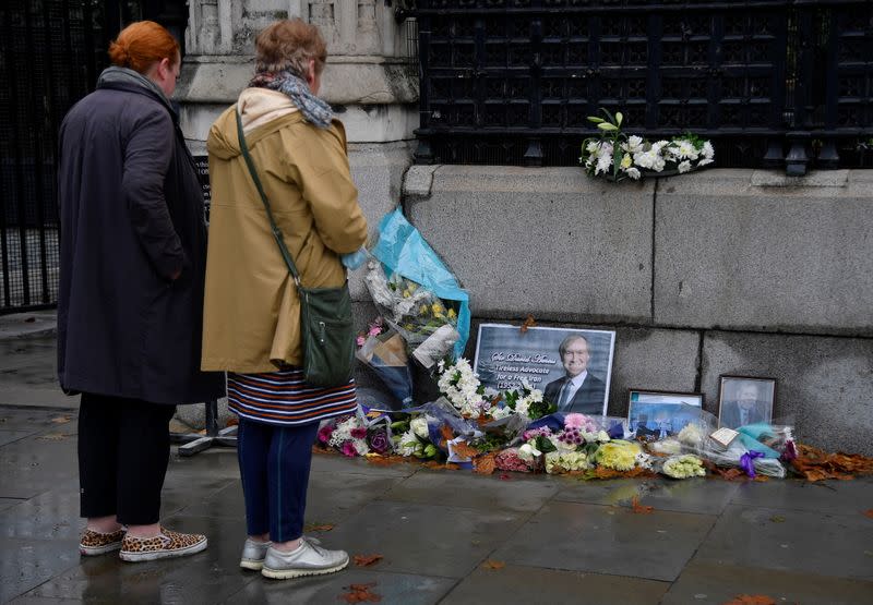 Tributes to British MP Amess placed outside the Houses of Parliament, in London