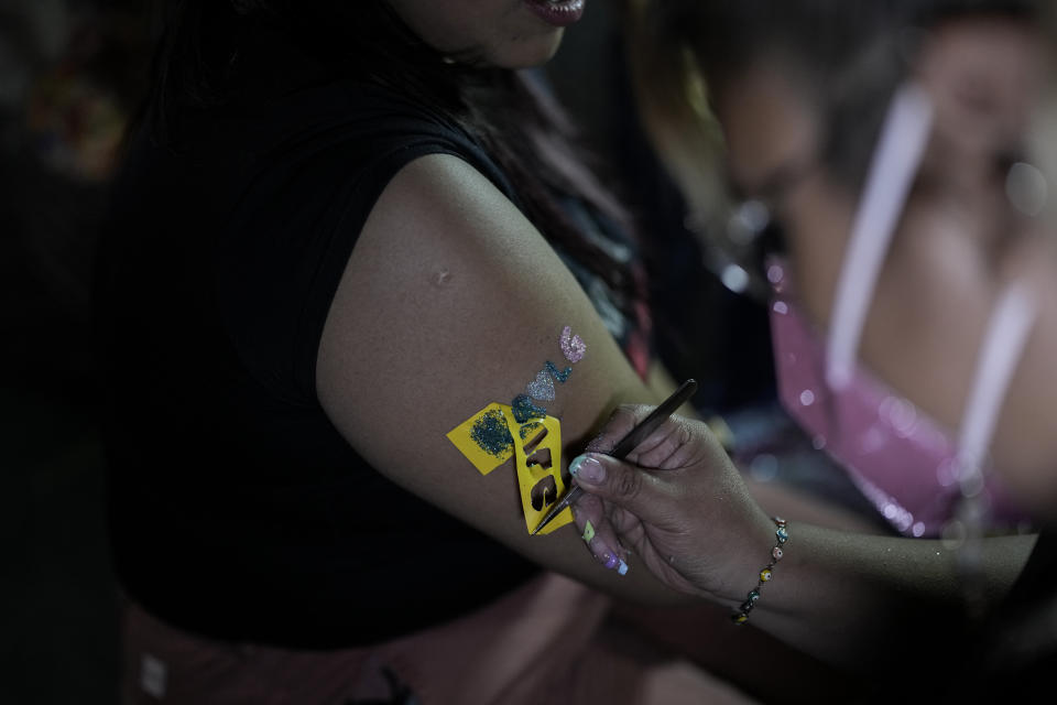 Una fan de Karol G se coloca un tatuaje temporal previo a un concierto de su gira "Mañana será bonito" en el Estadio Azteca de la Ciudad de México el jueves 8 de febrero de 2024. (Foto AP/Eduardo Verdugo)