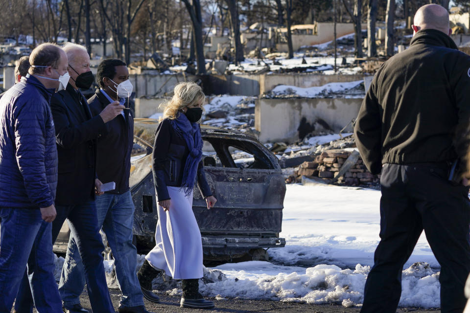 President Joe Biden and first lady Jill Biden tour a neighborhood in Louisville, Colo., Friday, Jan. 7, 2022, that was impacted by the recent wildfire, with Colorado Gov. Jared Polis, and Rep. Joe Neguse, D-Colo. (AP Photo/Susan Walsh)