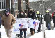 Victoria Wittenberg, 18 second from left, of Grosse Pointe Park and her mom Kelly Wittenberg, center, walk north on Wayburn St. during a walking rally to protest hate and racism in their neighborhood, Sunday, Feb. 21, 2021, in Grosse Pointe Park, Mich., following a white resident's display of a Ku Klux Klan flag in a side window facing their Black neighbor's home. JeDonna Dinges, 57, of Grosse Pointe Park, said the klan flag was hanging next door in a window directly across from her dining room. The incident occurred two weeks ago. (Clarence Tabb, Jr./Detroit News via AP)