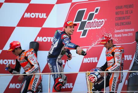 Spanish new World Champion Yamaha MotoGP rider Jorge Lorenzo (C) celebrates between Spanish Honda riders Marc Marquez (L) and Dani Pedrosa after winning the Valencia Motorcycle Grand Prix at the Ricardo Tormo racetrack in Cheste, near Valencia, November 8, 2015. REUTERS/Heino Kalis