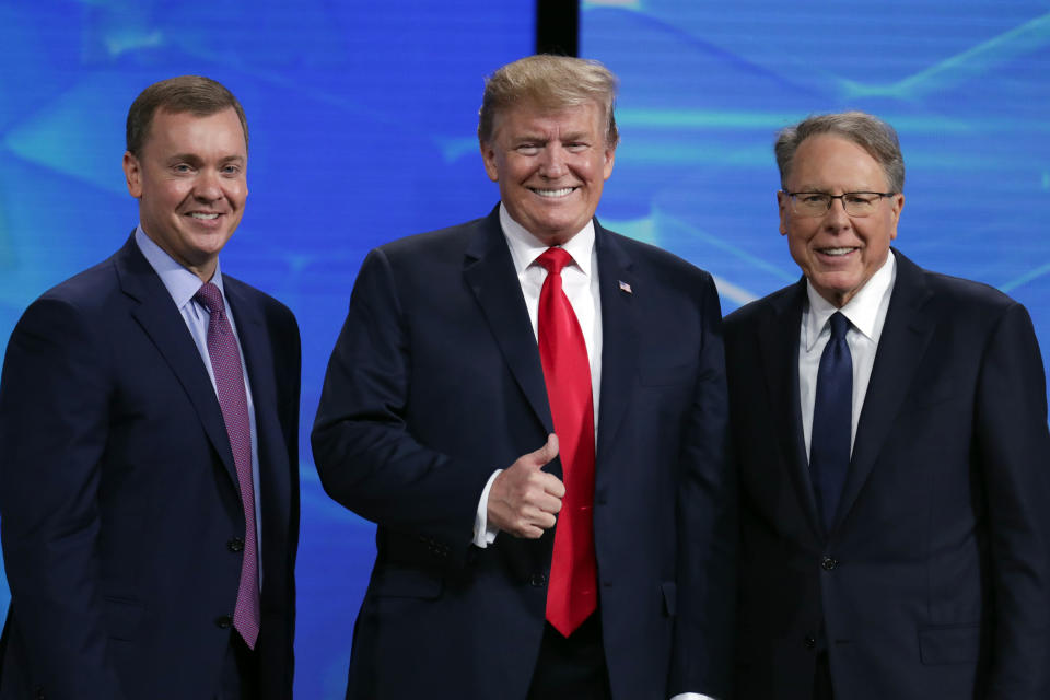 FILE - In this Friday, April 26, 2019 file photo, President Donald Trump poses with NRA-ILA Executive Director Chris Cox, left, and executive Vice President Wayne LaPierre before speaking at the National Rifle Association Institute for Legislative Action Leadership Forum in Lucas Oil Stadium in Indianapolis. The National Rifle Association is meeting in the shadows of Congress as its leaders remain under fire for spending and its operations. Amid the turmoil, lawmakers are considering steps to stem gun violence, including proposals long opposed by the NRA. (AP Photo/Michael Conroy, File)