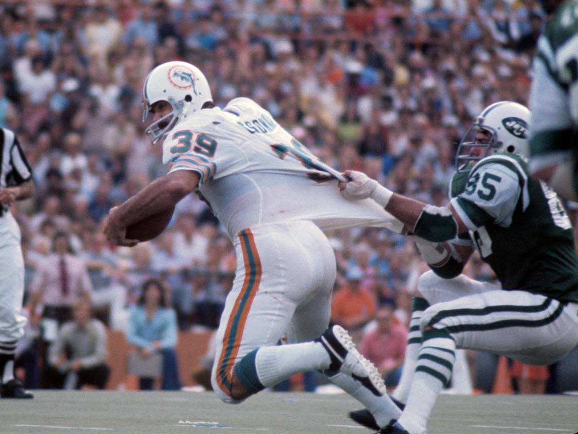 Defensive lineman Ed Galigher (85) of he New York Jets grabs fullback Larry Csonka (39) of the Miami Dolphins in 1972. (AP Photo / Al Messerschmidt)