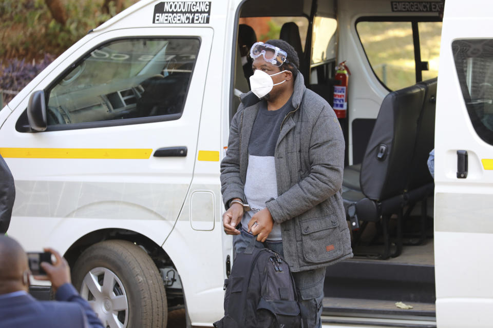 Zimbabwe journalist Hopewell Chin'ono appears at the magistrates courts while handcuffed in Harare, Wednesday, July, 22, 2020. Chin'ono known for exposing alleged government corruption is now accused of plotting against the government. Hopwell Chin'ono appeared alongside Jacob Ngarivhume, an opposition politician who is accused of conspiring with to mobilize anti government protests planned for July 31.(AP Photo/Tsvangirayi Mukwazhi)