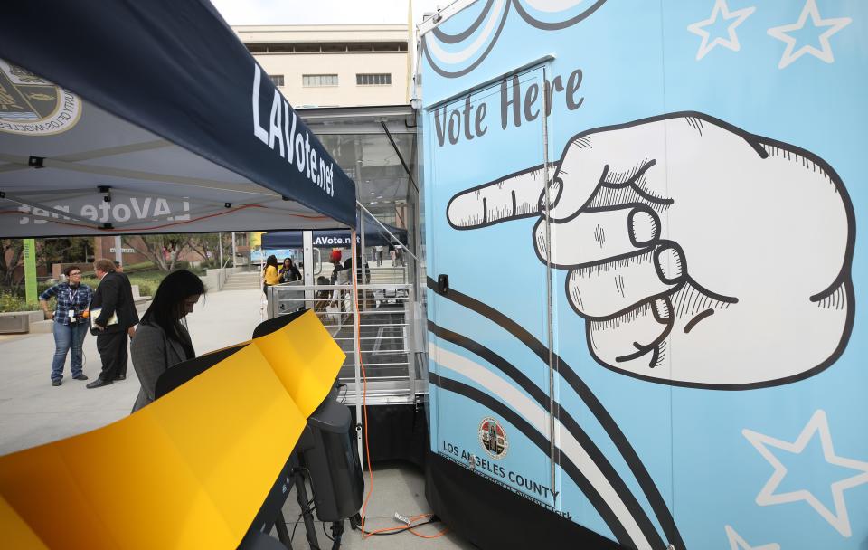 A voter prepares her ballot in a voting booth during early voting for the California presidential primary election at a new L.A. County Mobile Vote Center