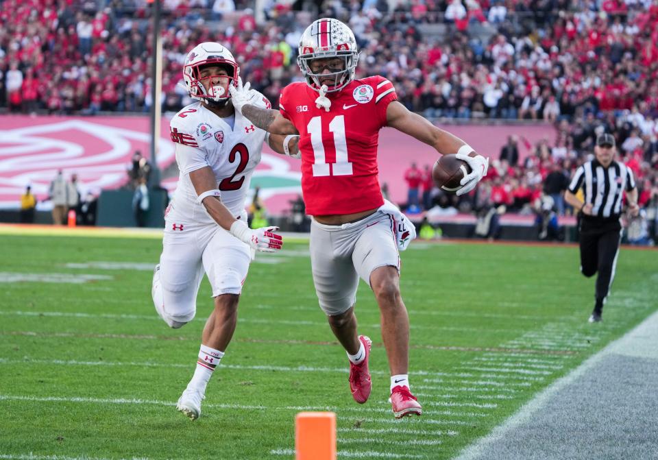 Ohio State wide receiver Jaxon Smith-Njigba fends off Utah cornerback Kenzel Lawler as he races to the end zone for a touchdown during the second quarter of the Rose Bowl.