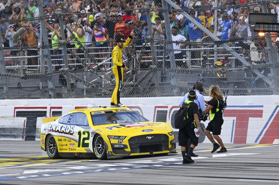 Ryan Blaney, center, celebrates with fans in the stands after winning a NASCAR Cup Series auto race at Talladega Superspeedway, Sunday, Oct. 1, 2023, in Talladega, Ala. (AP Photo/Julie Bennett)