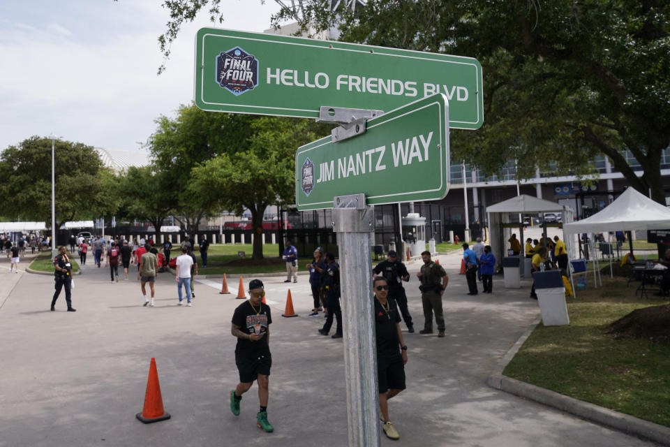 Fans walk past a Jim Nantz Way sign at NRG Stadium at the NCAA Tournament on Saturday, April 1, 2023, in Houston. (AP Photo/Godofredo A. Vasquez)