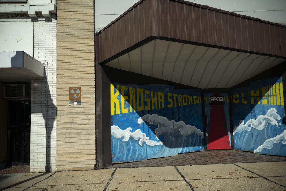 The windows of a shop front are boarded up with plywood which has a mural that reads "Kenosha Strong and BLM!" painted on it, Friday, Oct. 30, 2020, in downtown Kenosha, Wis. Two months after street violence shook the little lakeside city of Kenosha dozens of businesses are still boarded. Many of these businesses are open, but with divisive elections just days away some are also hedging their bets, covering up windows and sometimes building outer sets of plywood doors that can be easily shut, like castles pulling up their drawbridges, if trouble returns. (AP Photo/Wong Maye-E)