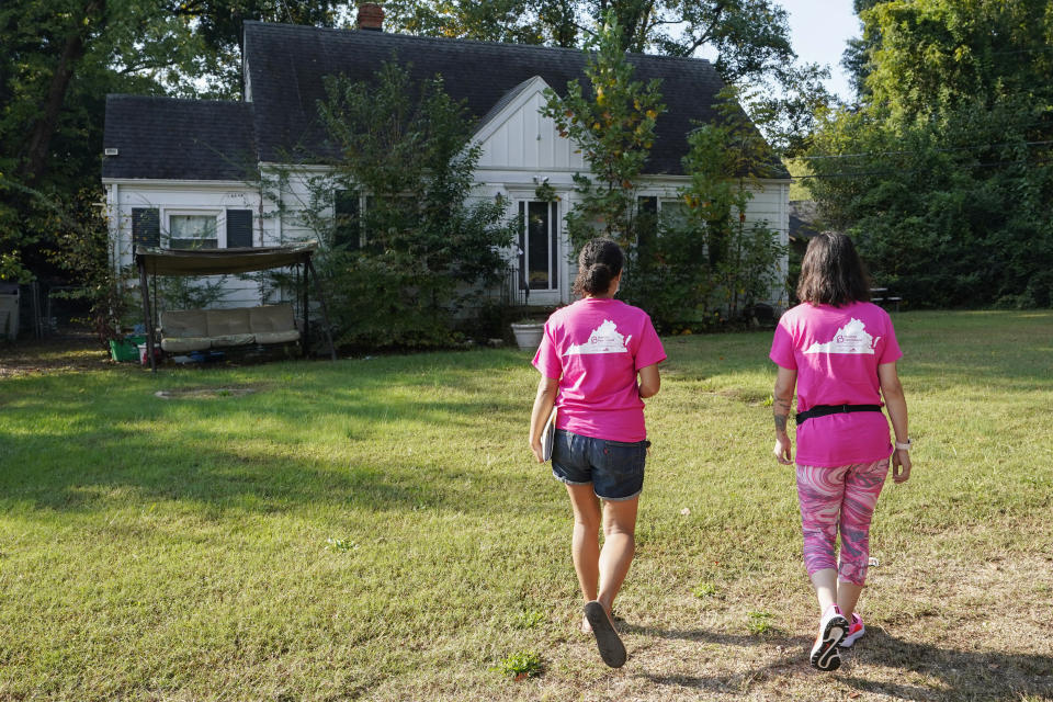 In this Saturday, Oct. 16, 2021, photo Han Jones and Lucy Hartman, of Planned Parenthood Advocates of Virginia knock on doors as they canvass the area to encourage voters to vote in Richmond, Va. (AP Photo/Steve Helber)