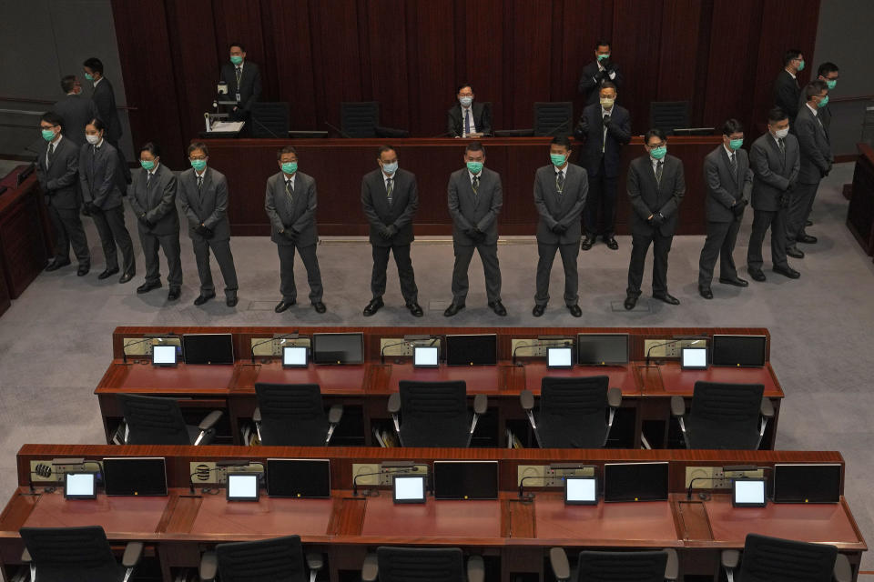 FILE - In this Monday, May 18, 2020 file photo, pro-Beijing politician, Chan Kin-por, top center seated, is surrounded by security guards during a Legislative Council's House Committee meeting in Hong Kong. Security guards have had to remove several pro-democracy lawmakers as the city's pro-democracy and pro-Beijing factions wrestle for control over a key committee that scrutinizes bills. (AP Photo/Vincent Yu, File)