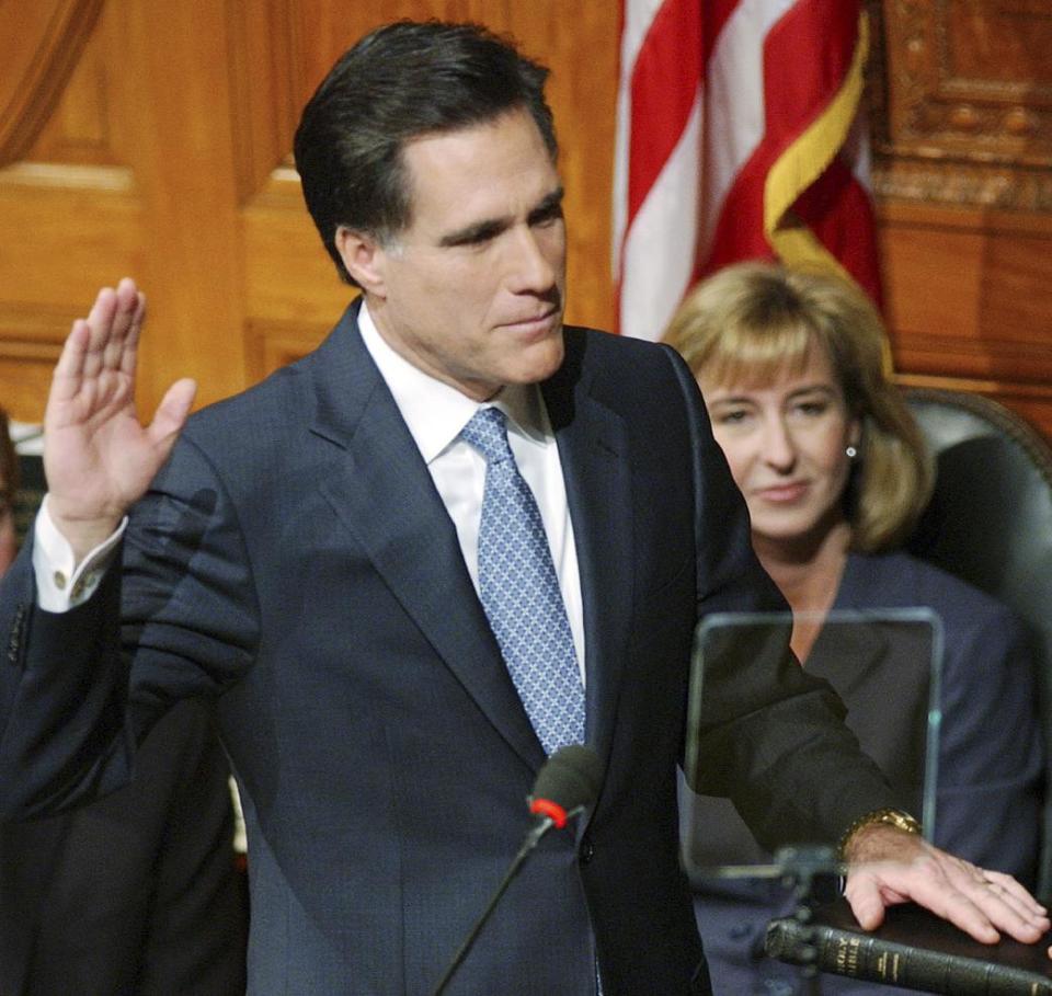 FILE - In this Jan. 2, 2003 file photo, Mitt Romney, accompanied by Lt. Gov.-elect Kerry Healy, takes the oath of office as governor of Massachusetts at the Statehouse in Boston. What worked in the corporate boardroom for Mitt Romney didn't fly in the more raucous corridors of the Massachusetts Legislature. The Republican took over as governor in 2003 after a long, successful career as CEO at private equity firm Bain Capital, where it was pretty much Romney's way or the highway. (AP Photo/Michael Dwyer, File)