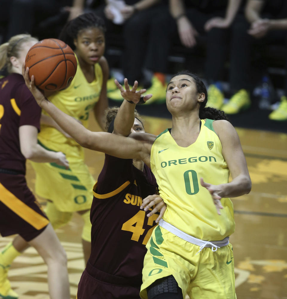 Oregon's Satou Sabally, right, goes up for a shot ahead of Arizona State's Courtney Ekmark, left, Oregon's Oti Gildon and Arizona State's Kianna Ibis during the fourth quarter of an NCAA college basketball game Friday, Jan. 18, 2019, in Eugene, Ore. (AP Photo/Chris Pietsch)