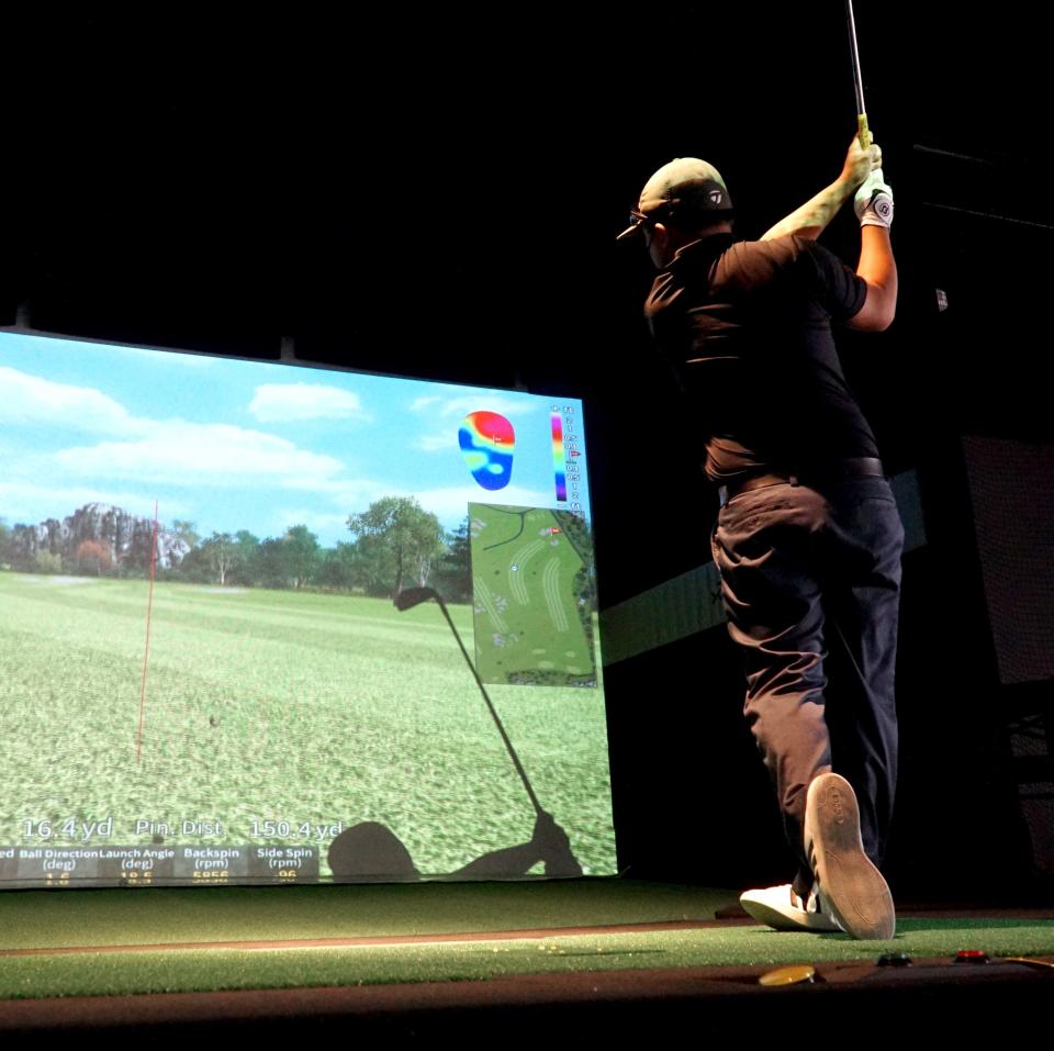                                Canton X-Golf pro Tony Mar tees off on one of its golf simulators.