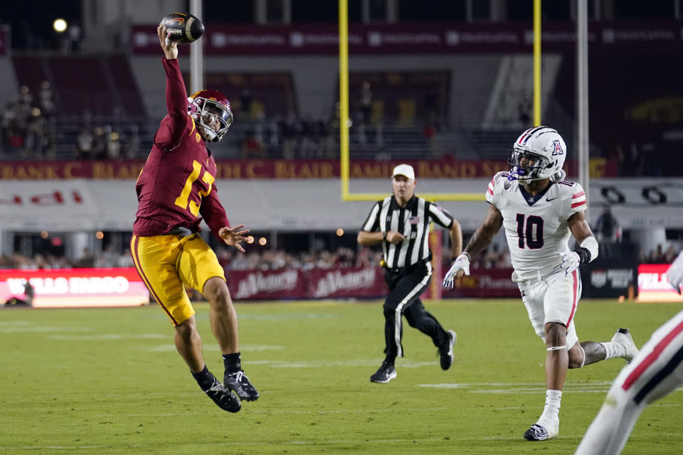 Southern California quarterback Caleb Williams (13) throws a touchdown pass to wide receiver Kyron Hudson as Arizona linebacker Justin Flowe (10) chases Williams during the first half of an NCAA college football game Saturday, Oct. 7, 2023, in Los Angeles. (AP Photo/Marcio Jose Sanchez)