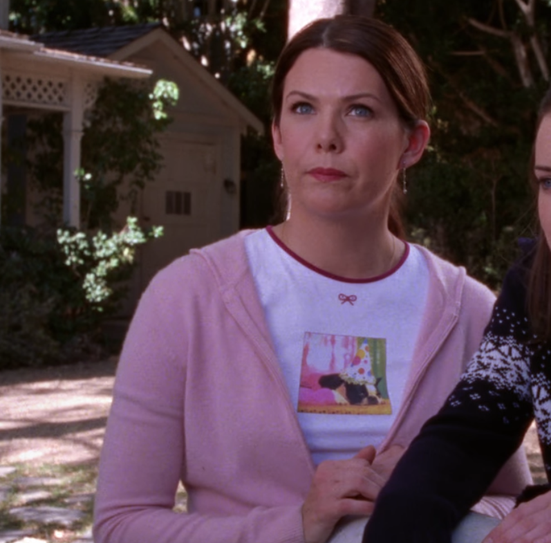 “Put a bow on it” feels a little literal, but that's exactly what Lorelai is doing with this look. Candy-pink zip-up hoodie and ultra-girly tee embellished with not one, but two images? That's early-season Lorelai, and we love her for it.