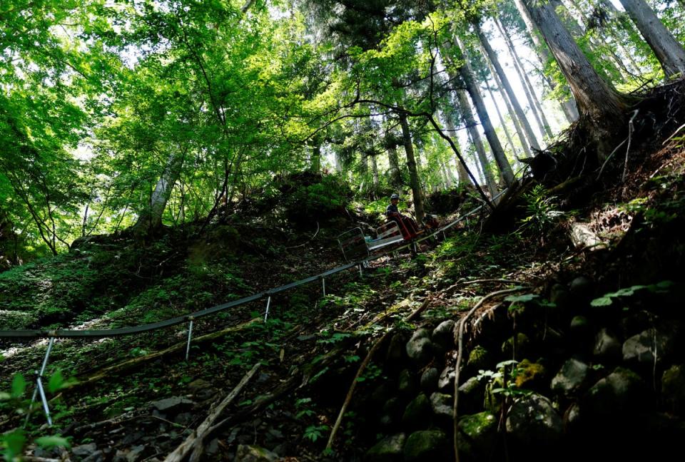 Masahiro Hoshina rides a Monorack railway to access his fields (Reuters)