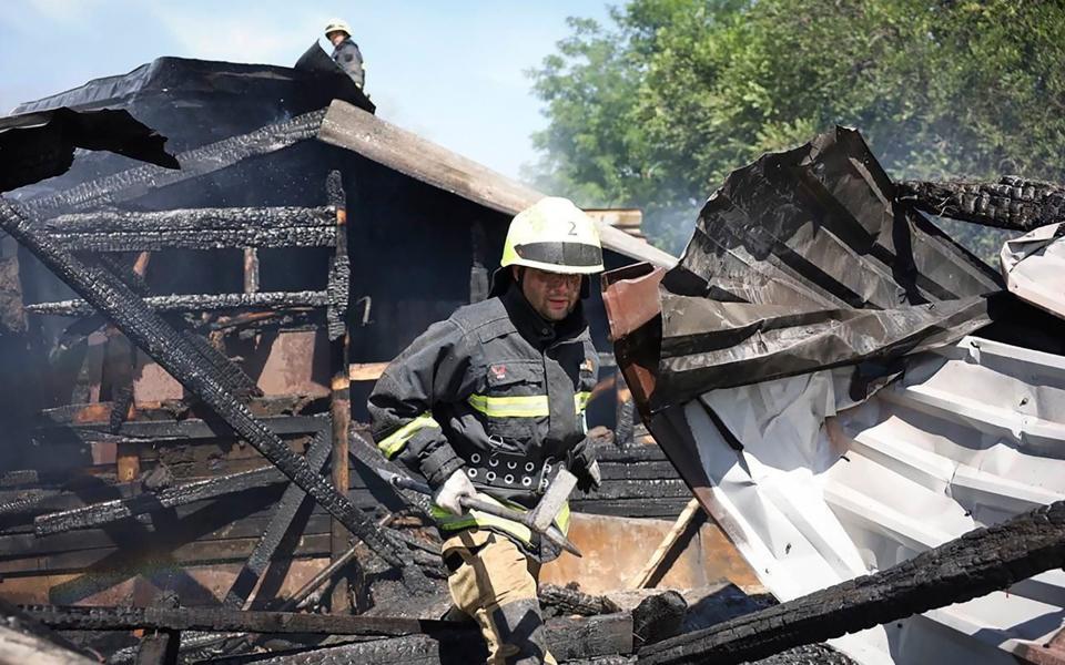 Rescuers work on the scene of a building damaged by the missile and drone onslaught