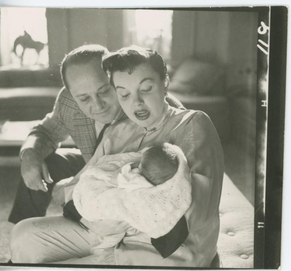 Sid Luft looks on as Judy Garland holds their son, Joey.