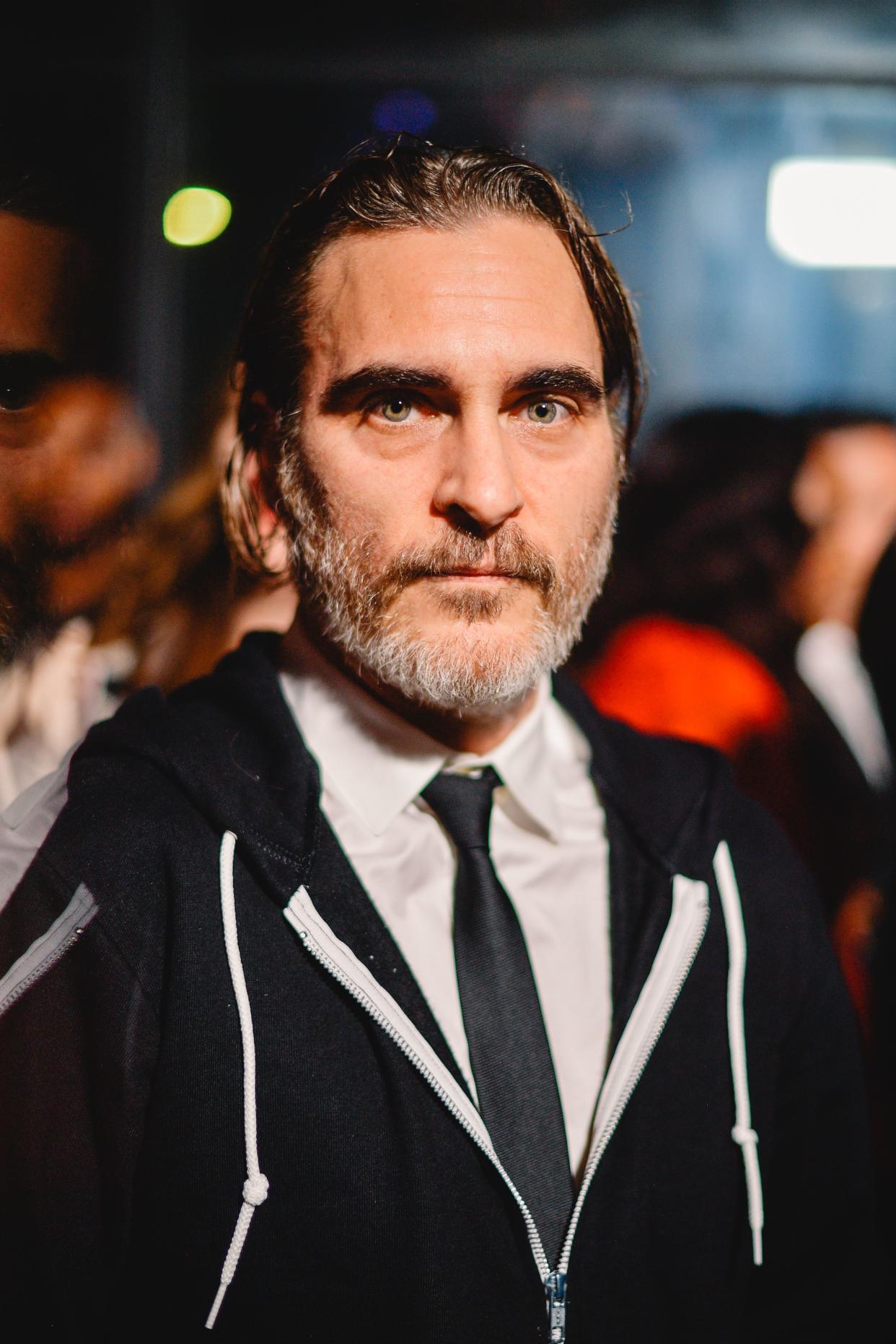 Age has nothing on Joaquin Phoenix as he looks amazing in a T-shirt and tie, with a black sweatshirt.
