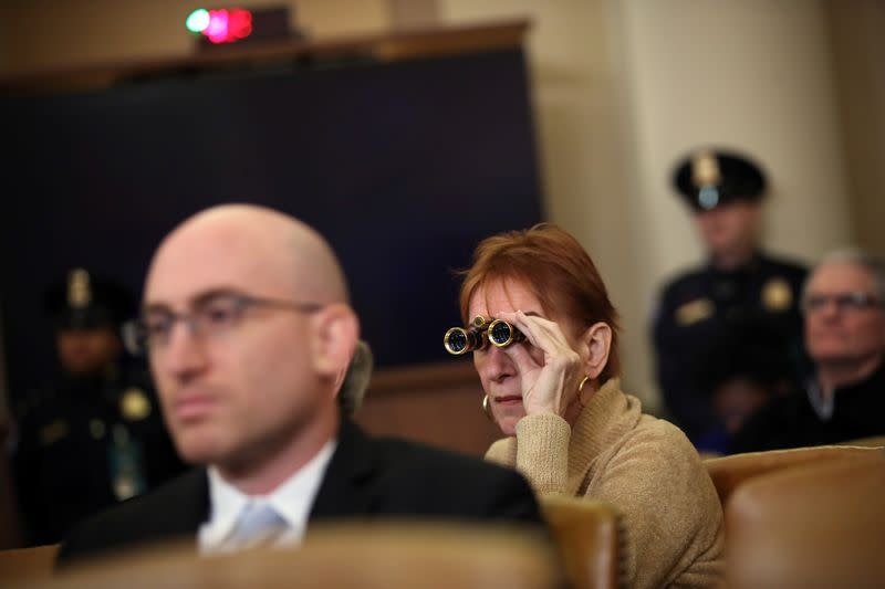 Member of the public uses binoculars as she watches the House Judiciary Committee hearing on the impeachment Inquiry into U.S. President Donald Trump on Capitol Hill in Washington