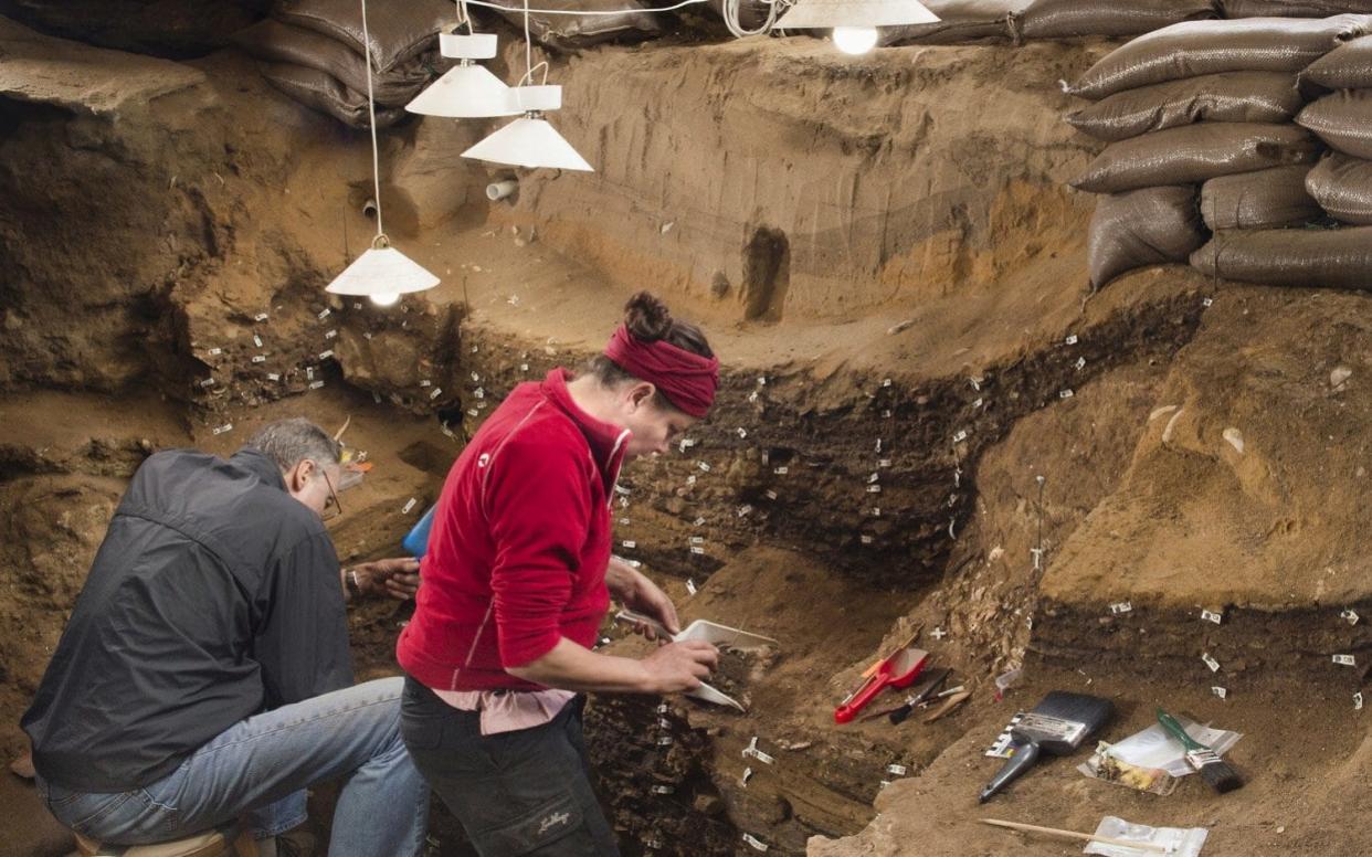 Researchers work inside Blombos Cave on South Africa's southern coast - REUTERS