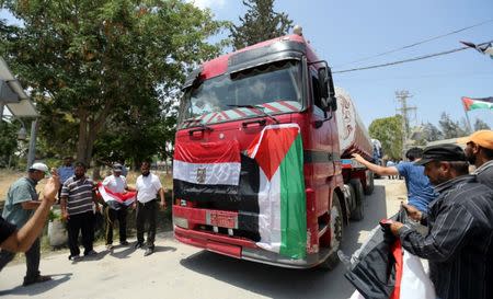 Palestinians watch as fuel tankers enter Gaza through the Rafah border between Egypt and southern Gaza Strip June 21, 2017. REUTERS/Ibraheem Abu Mustafa