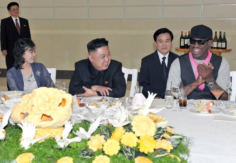 Kim Jong-Un (centre), his wife Ri Sol-Ju and Dennis Rodman at a dinner in Pyongyang last night. The pair were photographed joking together at the post-game reception, where Rodman, sporting a pink neck scarf and with piercings in his nose and lip, appeared to be enjoying a martini