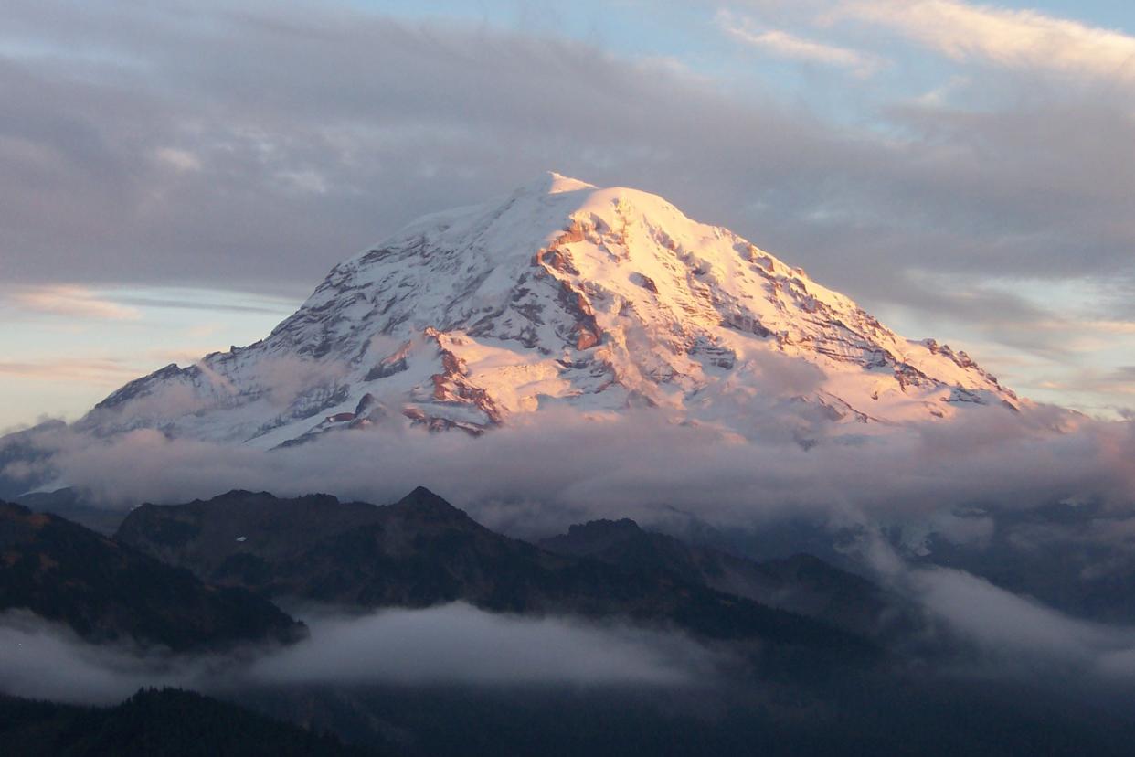 Clouds encircle Mount Rainier at sunset.