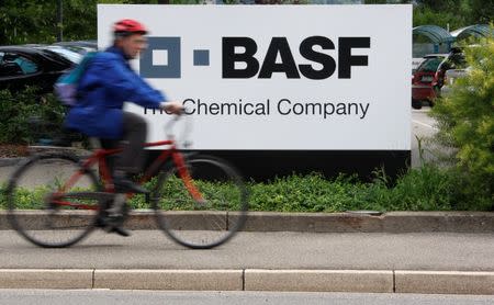 FILE PHOTO: A cyclist rides his bike past the entrance of the BASF plant and former Ciba production site in Schweizerhalle near Basel, Switzerland July 7, 2009. REUTERS/Christian Hartmann/File Photo