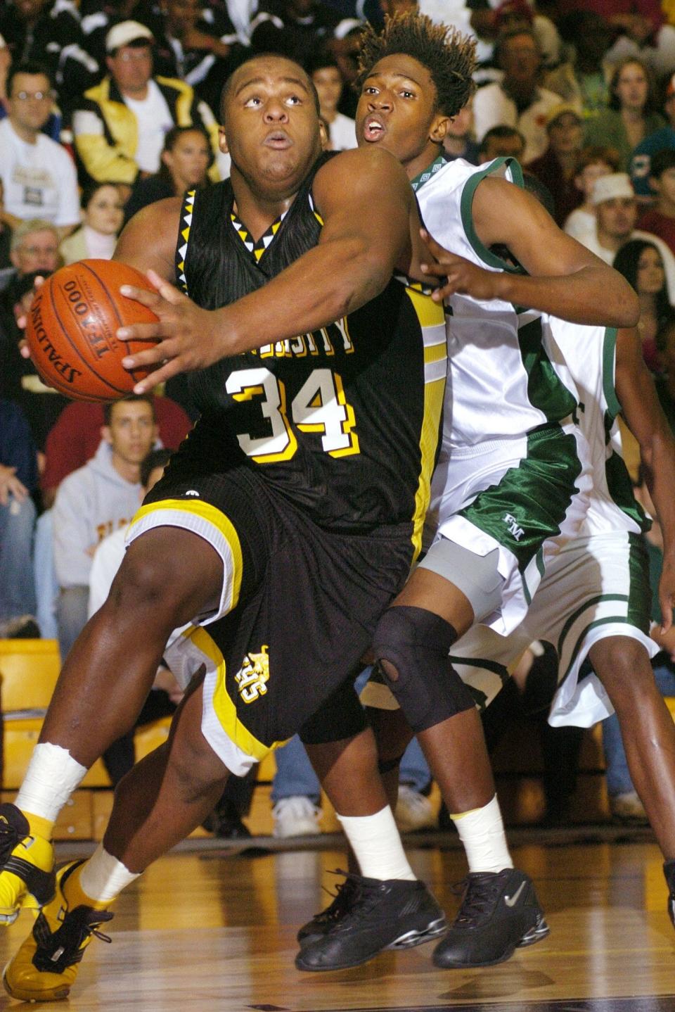 LSU Lab center Glen Davis drives towards the basket ahead of Fort Myers forward Dorvil Dorvilus during the Bank of America City of Palms Classic at Bishop Verot High School on Dec. 18, 2003.