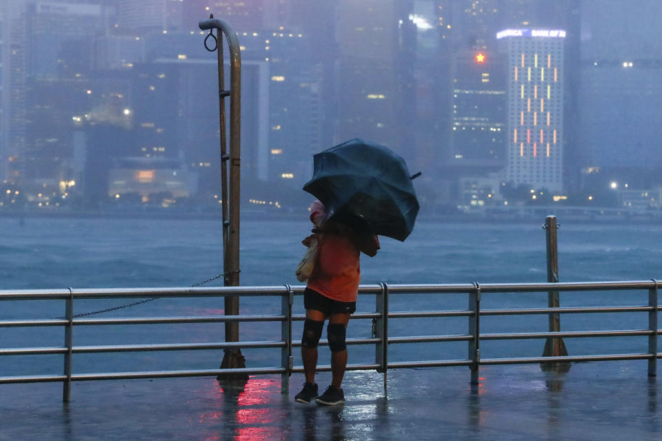 A person with an umbrella struggles against strong wind and rain brought by typhoon Saola in Hong Kong, on Friday, Sept. 1, 2023. Most of Hong Kong and other parts of southern China ground to a near standstill Friday with classes and flights canceled as powerful Typhoon Saola approached. (AP Photo/Daniel Ceng)