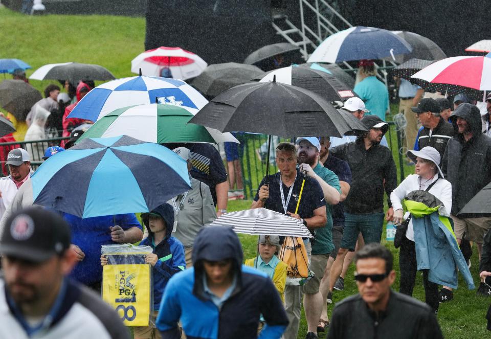 Golf fans pulled out their umbrellas and walked off the course during a weather delay in the PGA Championship practice round at the Valhalla Golf Course in Louisville, Ky. on May. 14, 2024.