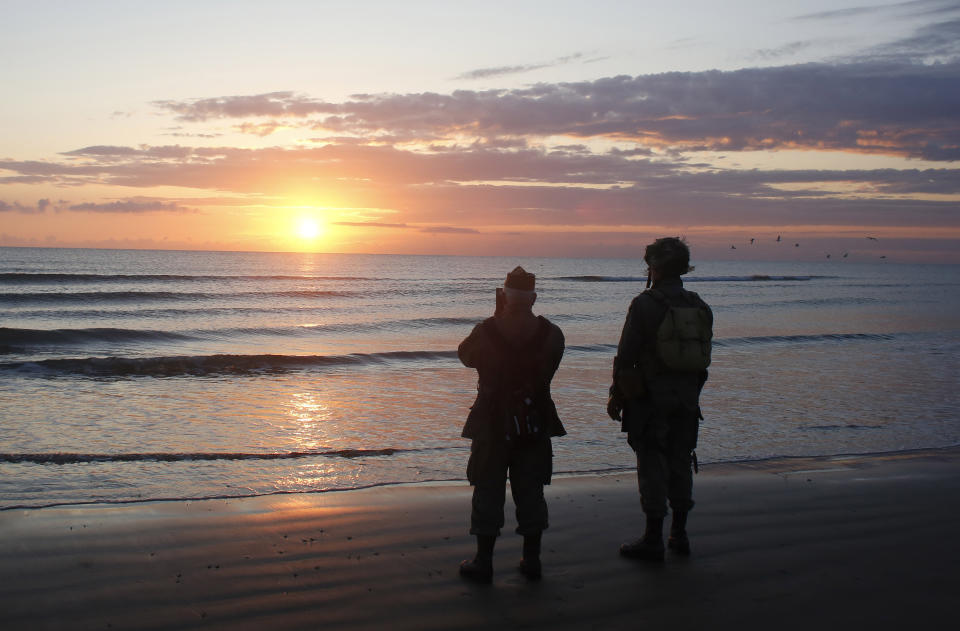 World War II reenactors stand looking out to sea on Omaha Beach, in Normandy, France, at dawn on Thursday, June 6, 2019 during commemorations of the 75th anniversary of D-Day. (AP Photo/Thibault Camus)