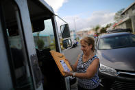 <p>A local resident receives a package from the U.S. Postal Service at an area affected by Hurricane Maria in San Juan, Puerto Rico, Oct. 6, 2017. (Photo: Carlos Barria/Reuters) </p>