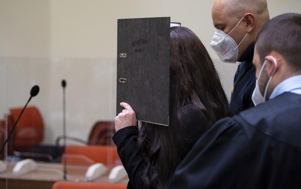 FILE - Defendant Jennifer W. arrives in a courtroom for her trial in Munich, Germany, Monday, Oct. 25, 2021. The woman from Lohne in Lower Saxony is charged with murder and war crimes. As an IS supporter in Iraq, she is said to have stood idly by while a small Yazidi girl was chained in a courtyard and died of thirst. (Sven Hoppe/dpa via AP, FILE)