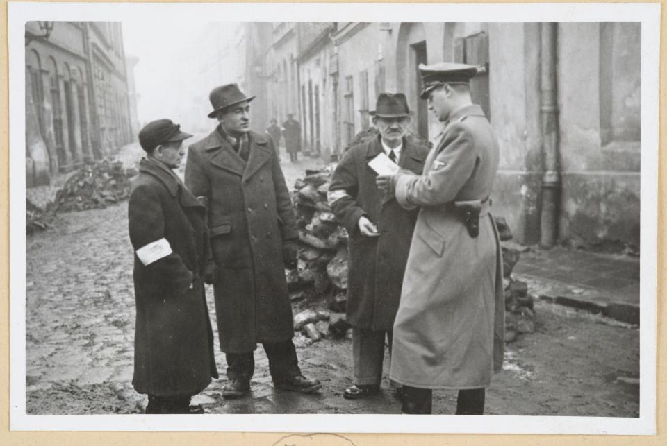 A Nazi officer checks the papers of Jewish residents in Poland in 1941.