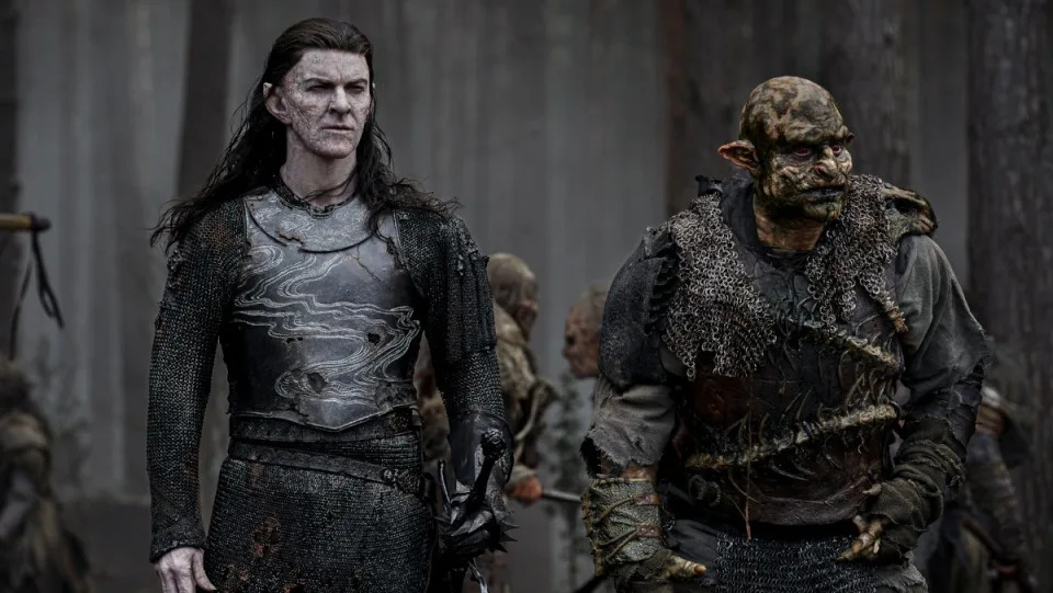 Adar walks beside an orc in a dark forest in season 2 of The Rings of Power